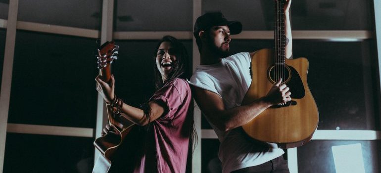 Woman and man holding their guitars at Caldwell's best live music venues and festivals