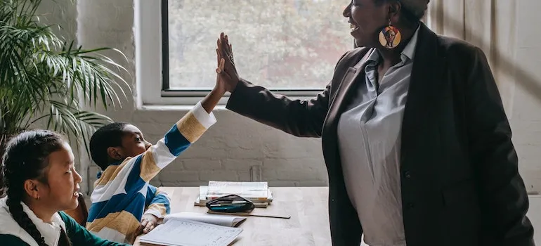 a teach high fiving a student