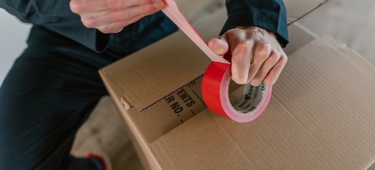 a man duck taping a box