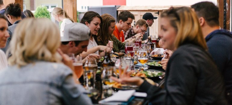 People at a table eating, drinking, and talking about Treasure Valley's friendly communities