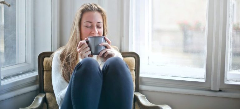 Woman relaxing, drinking coffee and thinking of techniques for finding calm in your new Boise home