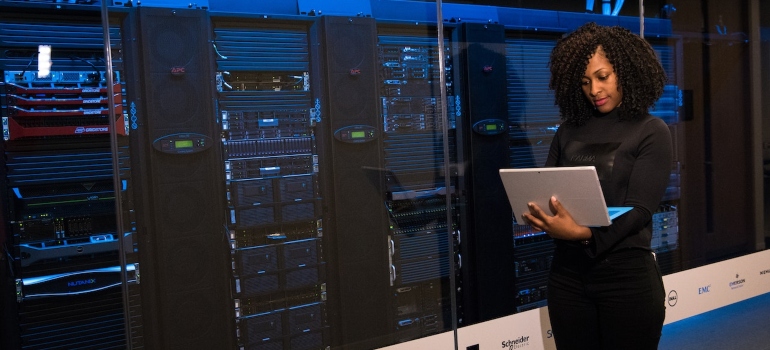 lady with curly hair holding laptop