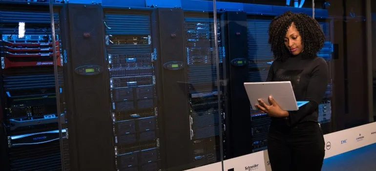 lady with curly hair holding laptop 