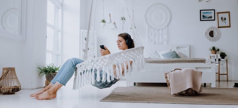 Woman with headphones relaxing and listening to music and researching techniques for finding calm in your new Boise home