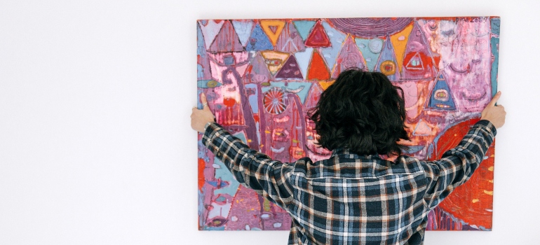 A woman hanging a picture on the wall