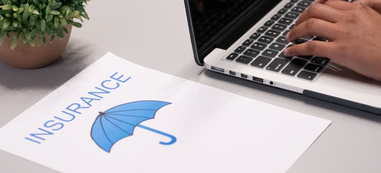 A blue umbrella insurance logo on a white paper near the laptop
