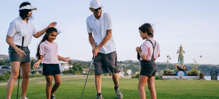 Parents playing golf with daughters