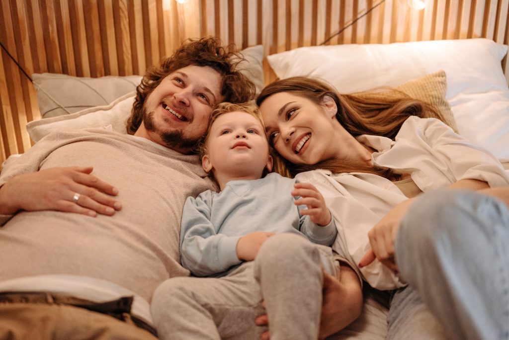 Parent and kid laying in bed