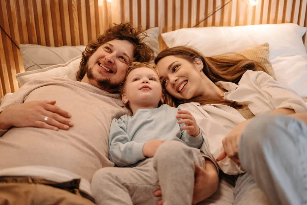 Parent and kid laying in bed
