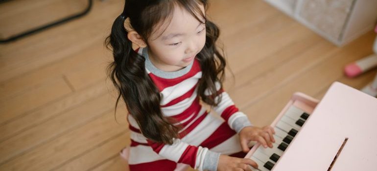 A little girl from one of the families moving to Nampa playing piano