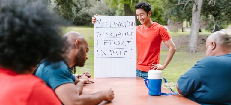 People at a workshop, moderator holding a bord with inspirational words listed