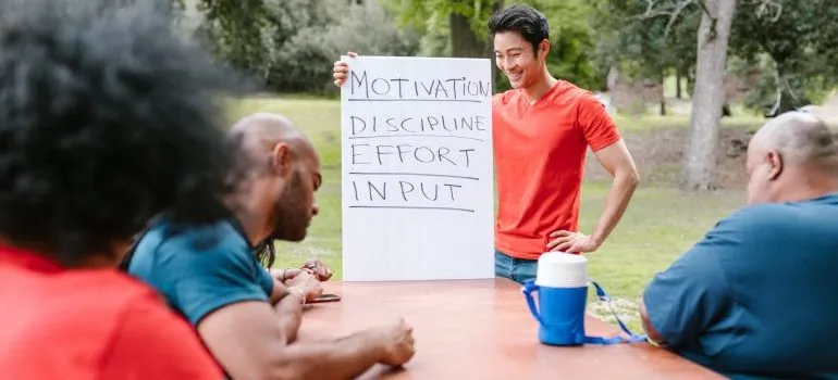 People at a workshop, moderator holding a bord with inspirational words listed