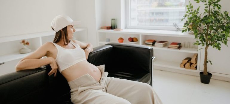A pregnant woman sitting on the couch and plans to move your home in Boise while pregnant