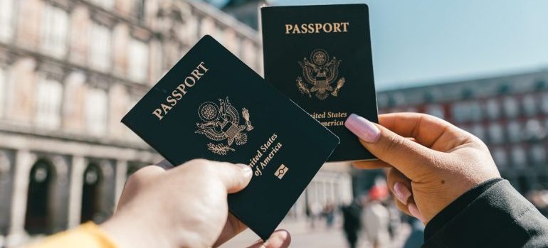 Two people holding US passports after relocating overseas from Idaho