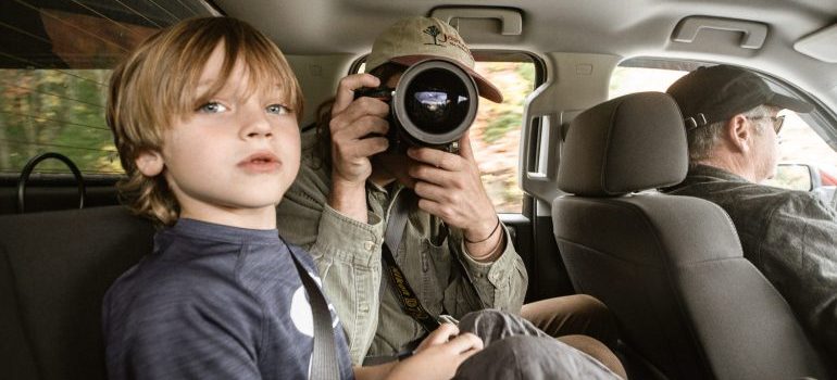 Kid and two adults taking a trip and taking photos of families moving to Nampa