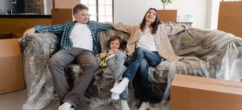 Family sitting on their new couch after hiring a full-service moving company