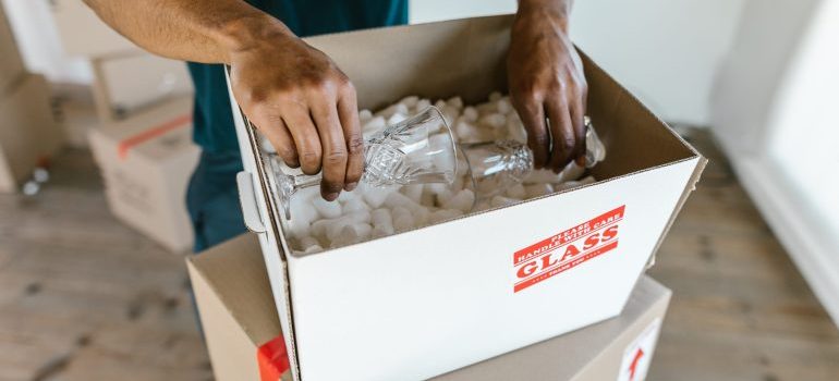 Man filling up a box with packing supplies