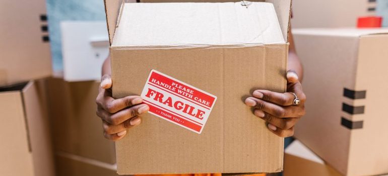 Woman holding a box she received after hiring a full-service moving company