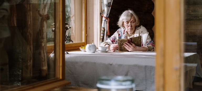 An elderly woman reading about the role of moving in major life transitions such as retirement