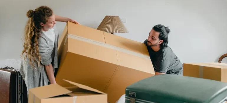 a couple moving a box during first week in your new Kuna residence