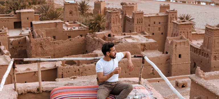 Man Sitting on Top of the Building While thinking of moving traditions and rituals around the world