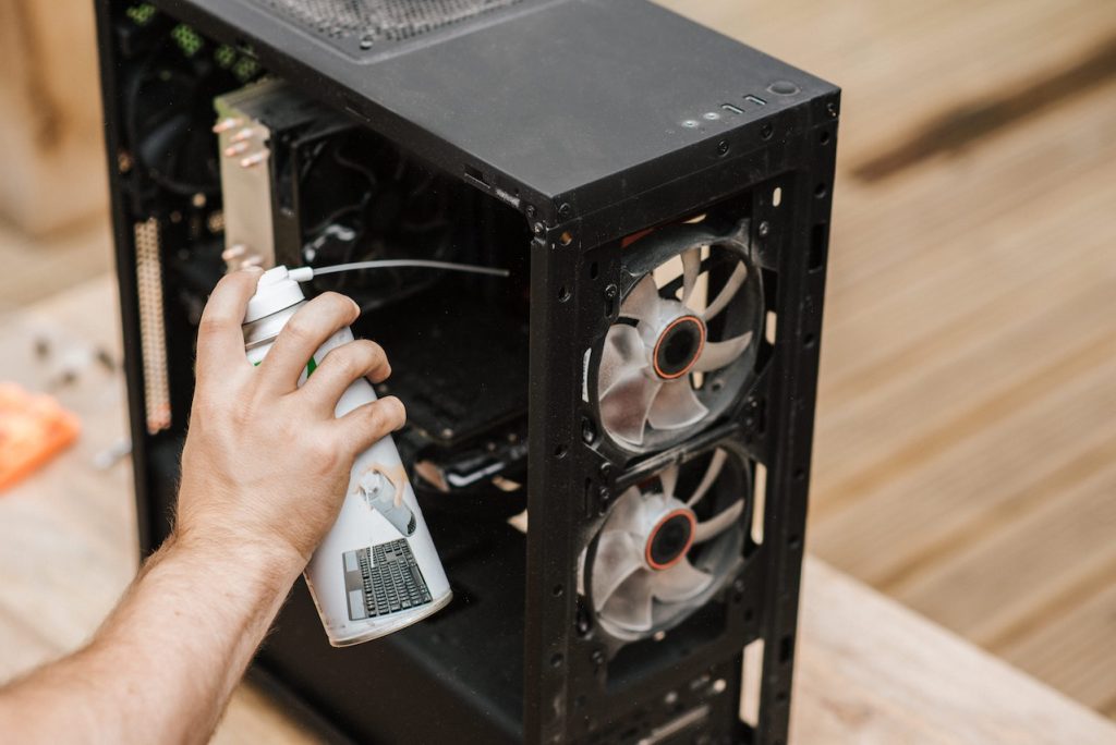 A man cleaning computer system unit to maintain your Boise office equipment