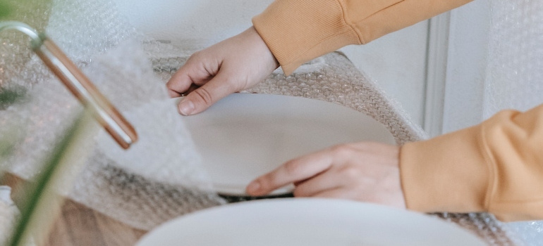 Woman Putting Bubble Wrap On Plates