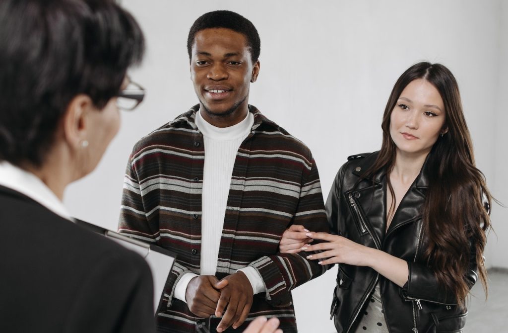 A woman explaining the rights and responsibilities of moving clients to a couple