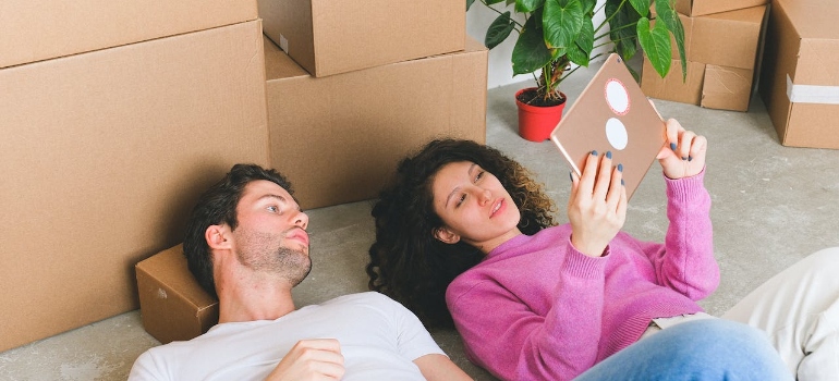A young couple lying on floor and looking at tablet