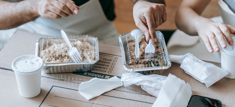 Couple Having Packed Food For Lunch on a moving box