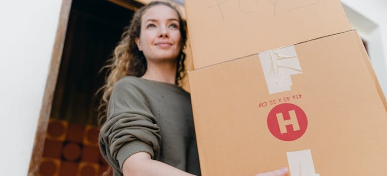 Young woman with boxes while moving out of your parents' house in Boise