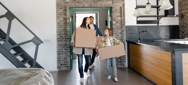 Parents and a son Carrying Cardboard Boxes managed to childproof your moving day