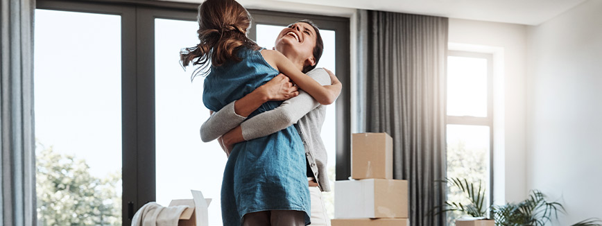 mom and daughter laughing and hugging after moving