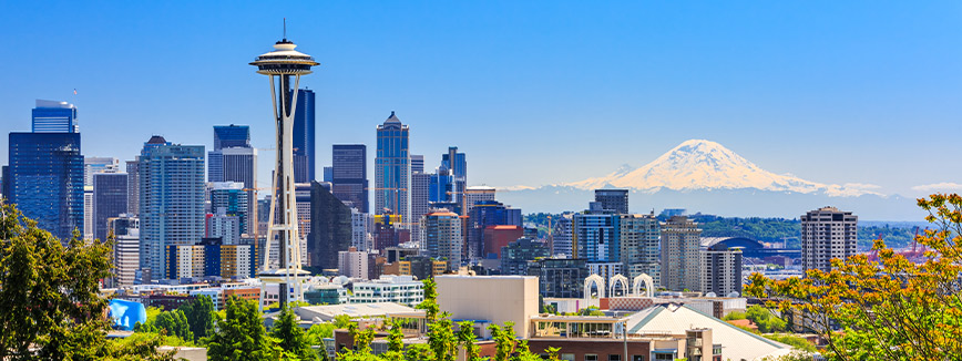 The skyline of Seattle, Washington, with its iconic Space Needle in the foreground and Mount Rainier in the background