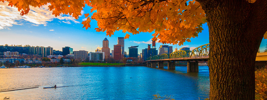Portland Oregon. Autumn landscape. A scenic river with a bridge, framed by a city skyline, symbolizing the transition to life in the Pacific Northwest.