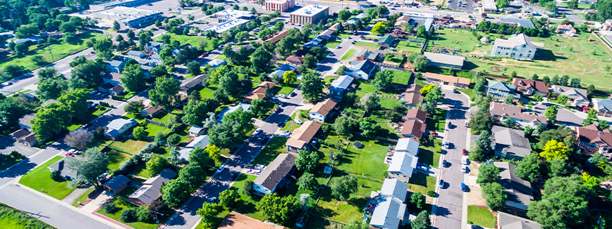 Aerial view of a residential neighborhood showcasing colorful fall foliage in Idaho transitioning to Colorado.