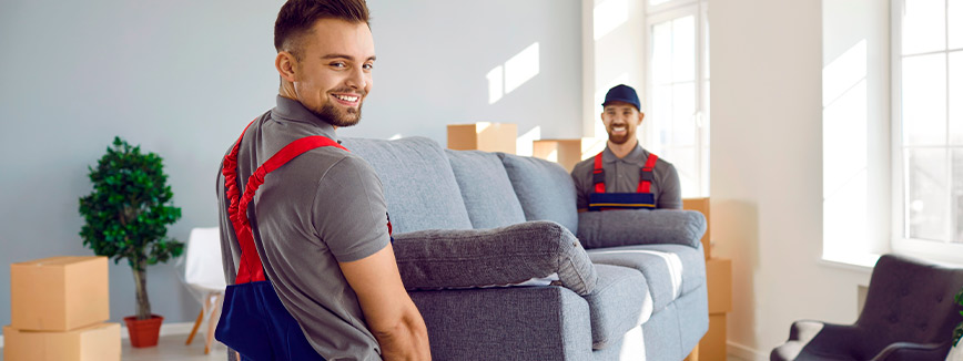 Two men in a cluttered room with boxes and furniture, exploring professional moving services in Meridian.