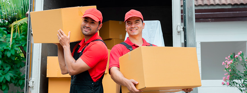 Two men in red shirts lift boxes into a moving truck, showcasing the efficiency of professional movers in Meridian.
