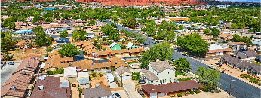 Aerial perspective of a town with houses and trees, highlighting the community setting relevant to moving from Idaho to Utah.