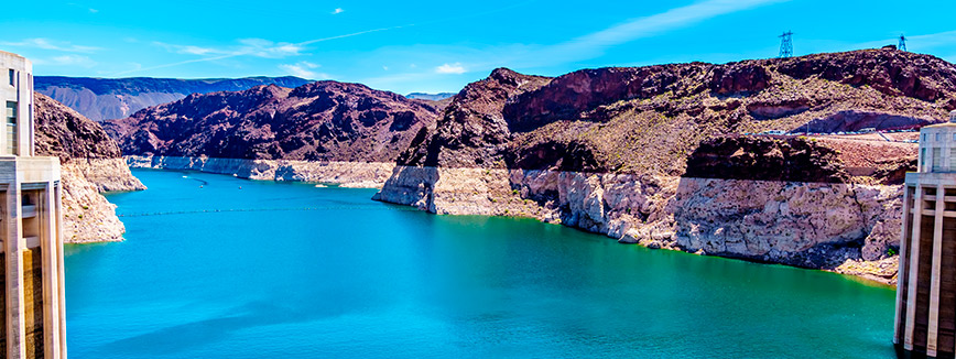 A serene view of a large body of water with majestic mountains rising in the background, evoking tranquility and nature's beauty.